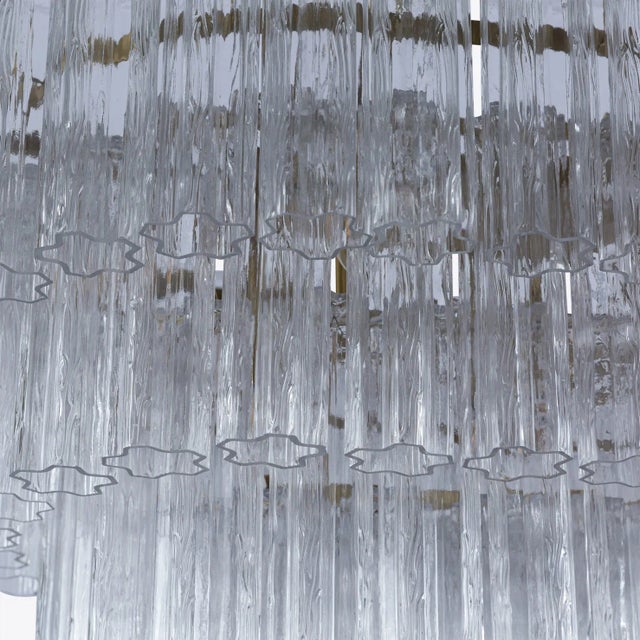Four tiers of fluted glass tubes create this beautiful mid-century inspired dining chandelier. The textured glass tubes...