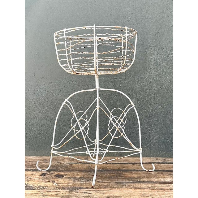 This vintage wire plant stand rises in a graceful hourglass silhouette, pairing a deep, bowl-shaped basket with a domed...