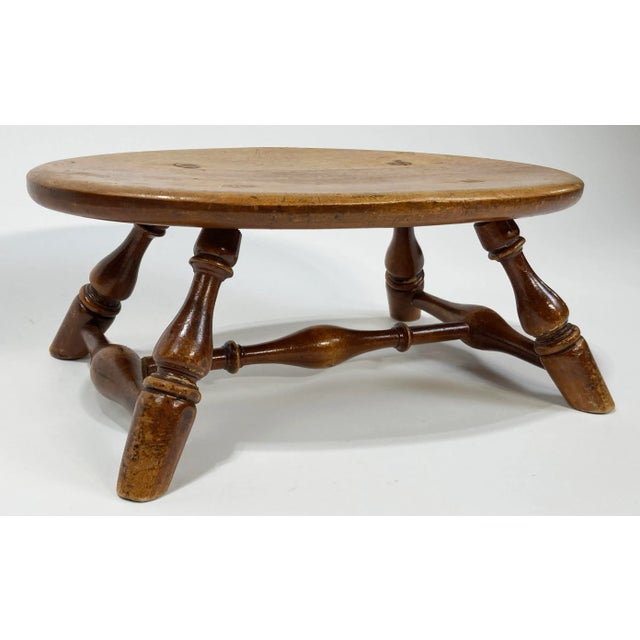 Turned wood milking stool with wonderful patina. Turned legs secured with stretchers between. Measures 6.25"H. Age wear....