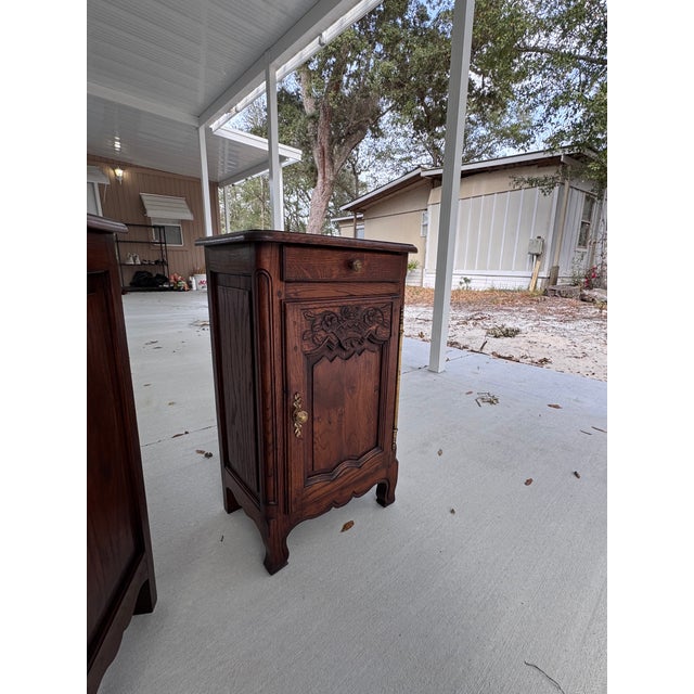 These are a pair of antique French Provincial style oak jam cabinets, or "confituriers," featuring intricate hand-carvings...
