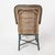 A charming vintage French rattan armchair, blending classic woven wicker craftsmanship with a sculptural, painted wood...