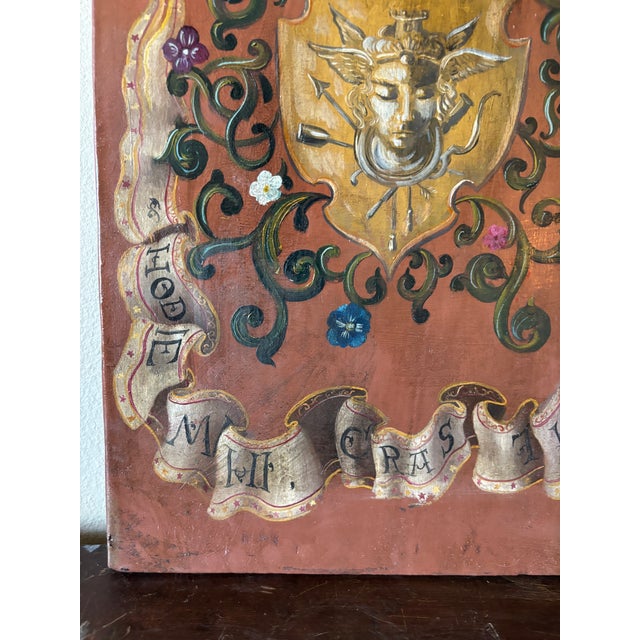 This rare hand-painted oil on wood memento Mori coat of arms heraldry wall plaque with painted goat under two swords on...