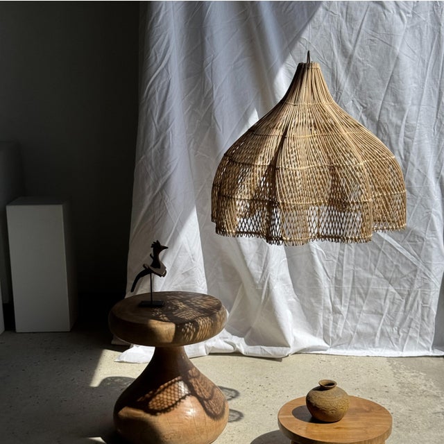 Traditional Indonesian decorative wooden bird on a base, featuring a crest, rounded wings, and a metal bar. Bird...