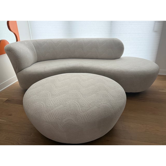 Sculptural curved sofa and ottoman in the style of Vladimir Kagan, featuring an elegant serpentine silhouette and fully...