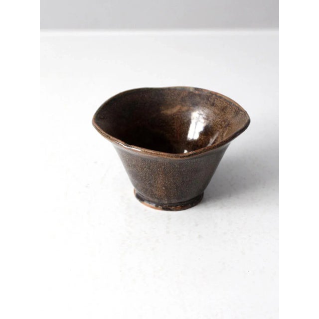 This is a vintage studio pottery bowl. Signed by the artist, the handmade bowl has a free-form abstract fluted design with...