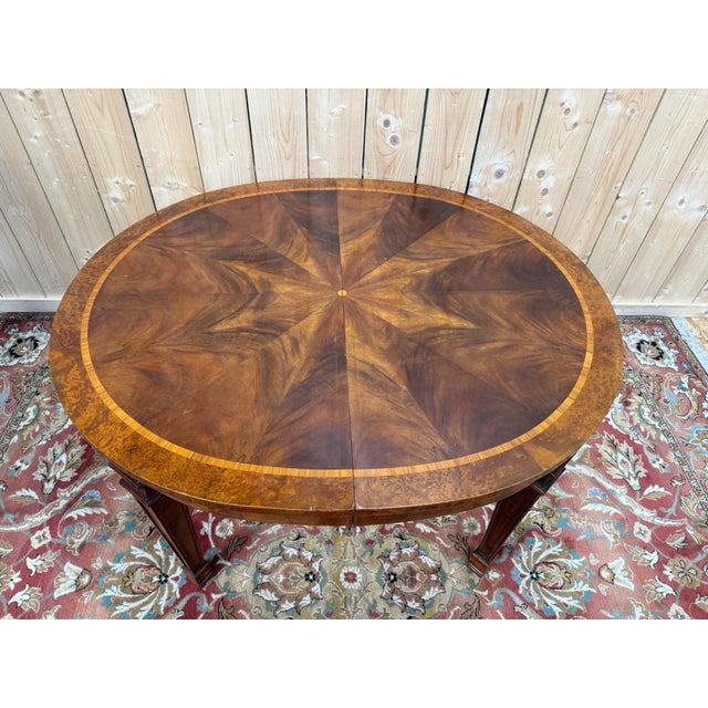 Oval dining table, late 19th century, louis xvi style, with a book-matched walnut marquetry top featuring a star motif....