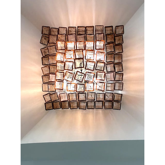Elegant contemporary wall sconces made in amber-Rosè Murano glass “squared” elements. “Squared ” are blown inside a wooden...