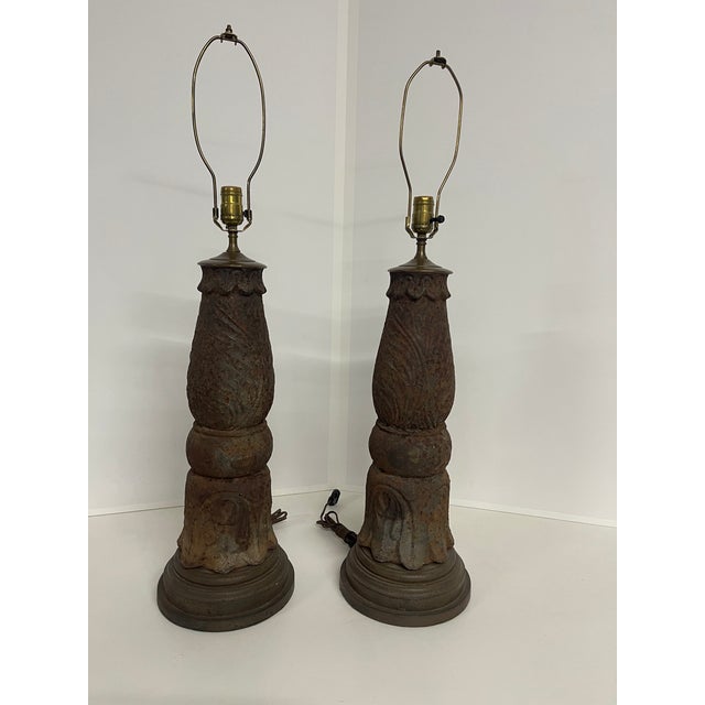 An antique matching pair of ornate cast iron table lamps with significant age-related oxidation and patina, Victorian-...