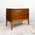 Constructed in walnut veneer over a plywood carcass, with dovetailed drawer boxes and a solid timber base and tapered...