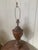 A beautiful vintage Neoclassical style brown tole lamp with hand-painted foliate swag and fruit accents. There are two...