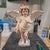 This standing cherub opens its feathered wings while one hand rests gently over the chest. An ivory drape, warm painted...