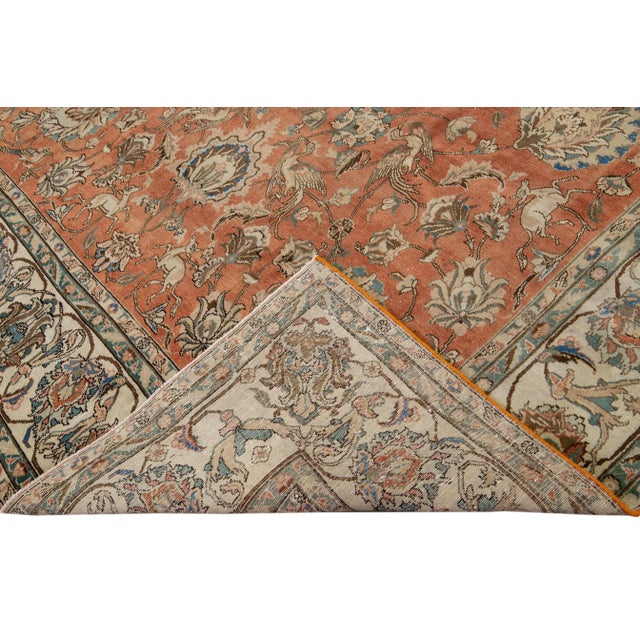 Beautiful antique Persian Tabriz hand-knotted wool rug with a rust field. This piece has a beige frame and multicolor...
