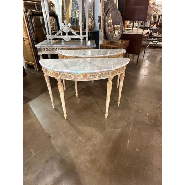 Pair of Italian carved and painted demi-lune consoles with Carrara marble tops. Circa 1940. A timeless and classic touch...