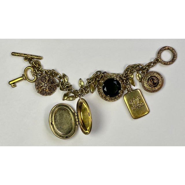 Antiqued gold-toned charm bracelet with a toggle clasp, six charms including a functional locket, a charm with the RL...