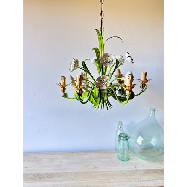 Vintage six-light tole chandelier constructed of painted metal with hand-formed floral and foliate decoration. The fixture...