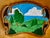 A richly textured vintage hand-tooled leather landscape mounted in a carved wood frame. The dimensional leatherwork is...