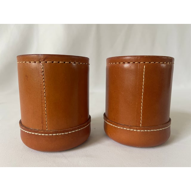 Pair of brown leather dice cups, with hand stitched exterior. They are in good condition with a wonderful aged patina.