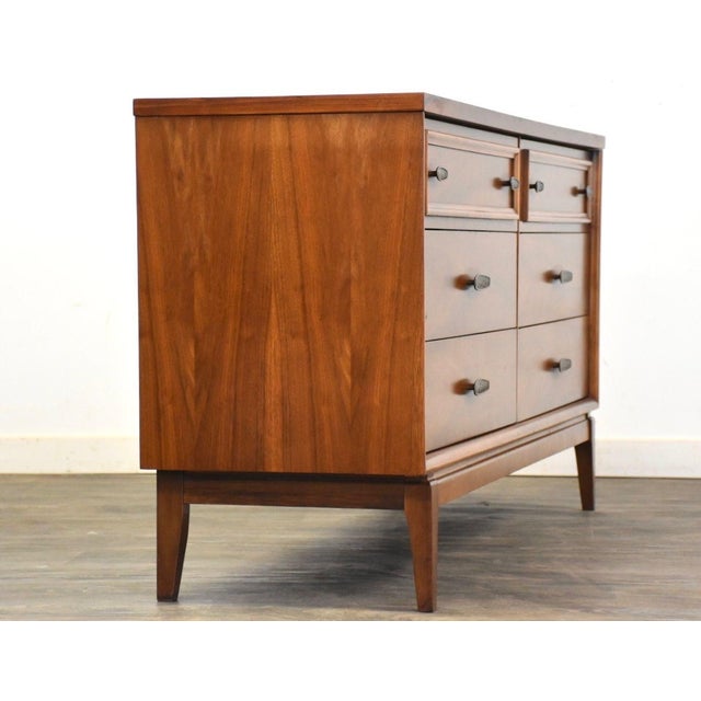 A mid century modern walnut six drawer dresser with bronze color hardware. Unmarked. 60” wide. 18” deep. 30.75” tall.