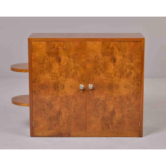 This Art Deco cabinet showcases book-matched burl walnut veneer across the door fronts and sides. Two doors with chrome...