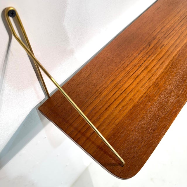 This set of two danish mid-century teak floating shelves, designed in the 1960s, embodies timeless elegance. Crafted in...