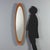 Elliptical mirror from the 1960s featuring a teak wood frame. The tapered, minimalist design perfectly reflects the taste...