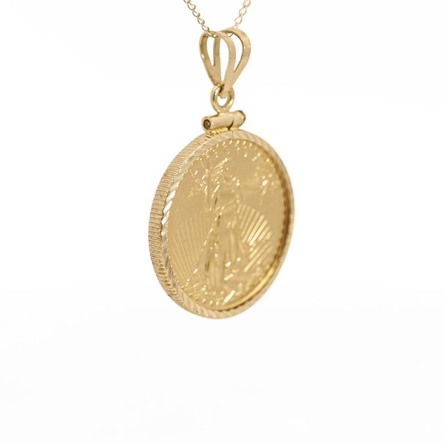 This exquisite pendant features the iconic US Liberty $10 coin, minted in 2010 in 22K solid gold and set in a 14k reeded...