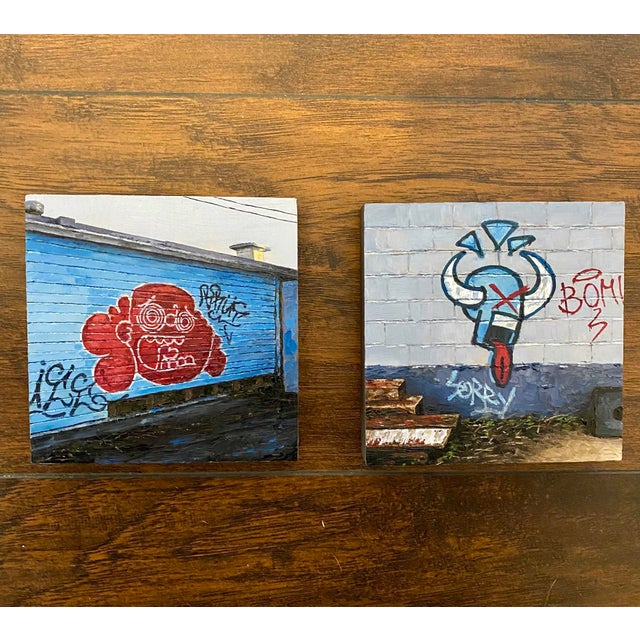 This artwork features a vibrant graffiti mural of a cartoonish figure with exaggerated features, set against a striking...