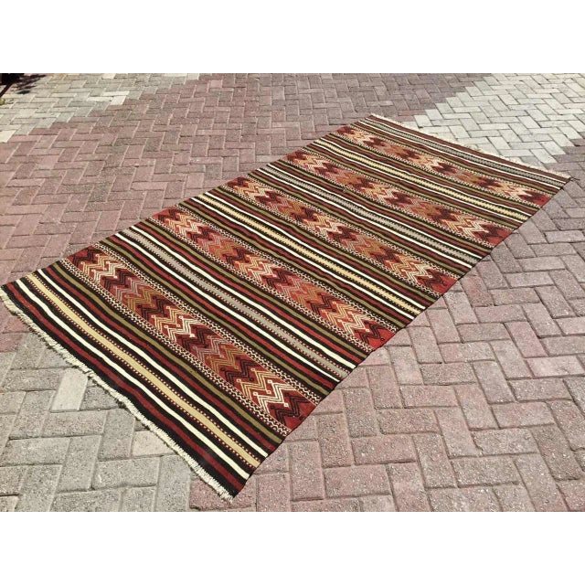 This beautiful, traditional vintage, flatweaved Turkish kilim rug is approximately 60 years old. It is handmade of very...
