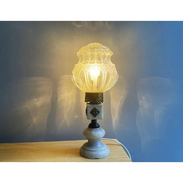 Portuguese 1660s Art Deco style table lamp. The body is made of alabaster with brass details , the globe is in glass. Has...