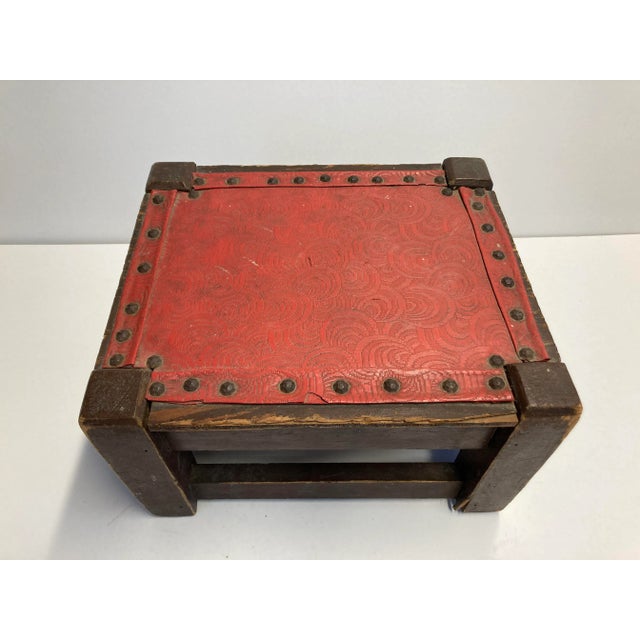 Bohemian low stool with red patterned vinyl seat in fair condition