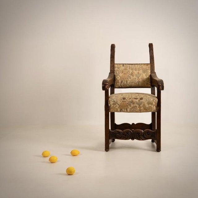 EARLY PERIOD Wingback armchair France, 18th century Carved and stained oak, fabric decorated with medieval scenes Height...