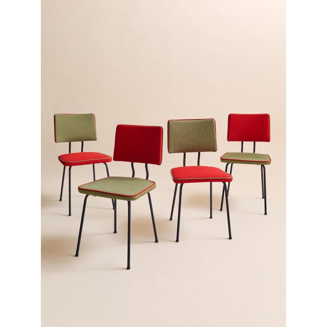 A vibrant set of four 1950s mid century modern dining chairs featuring sculptural black metal legs and newly upholstered...