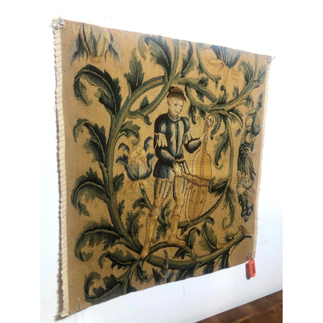 Hand woven 100% wool tapestry fragment featuring male figure with cello in gold, green and blue hues. Right facing....