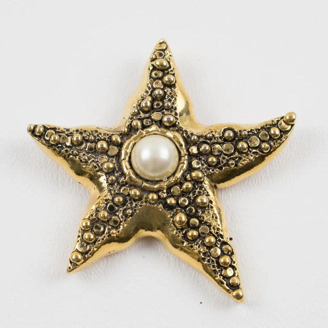 This elegant Guy Laroche Paris pin brooch features an oversized starfish shape in gilt metal, ornately carved and...