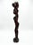 A striking and commanding 35-inch tall hand-carved solid hardwood sculpture depicting an African woman carrying a...