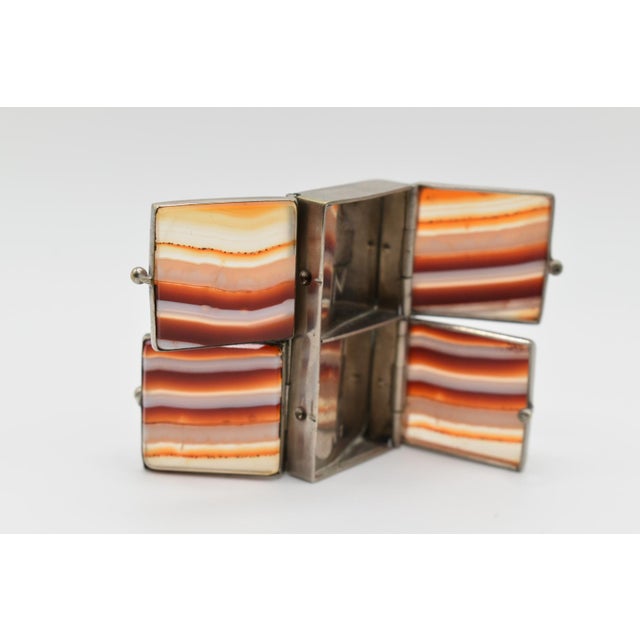 This is an adorable agate and silver pill box. It is equipped with four separate compartments.
