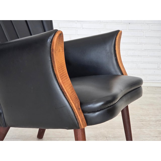 1970s, Danish design by Svend Skipper. Armchair, model "Teddy". Original black artificial leather, teak wood legs, beech...