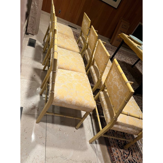 Chic and timeless set of eight vintage faux bamboo dining chairs, featuring beautifully carved wooden frames with a...