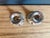 A pair of vintage silverplate candle holders in a low, traditional form. Each has a wide flared drip pan over a tapered...