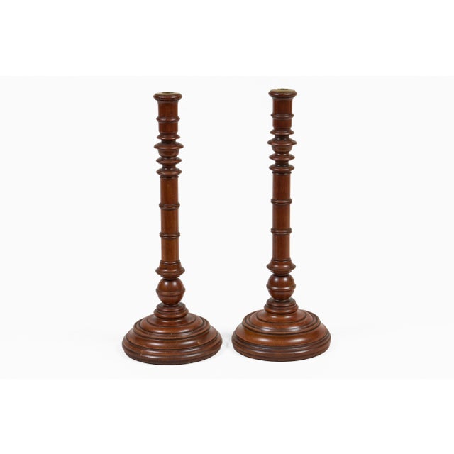Pair of tall mahogany turned and weighted candlesticks, the column with ring and vase turnings, ball shape at base and a...