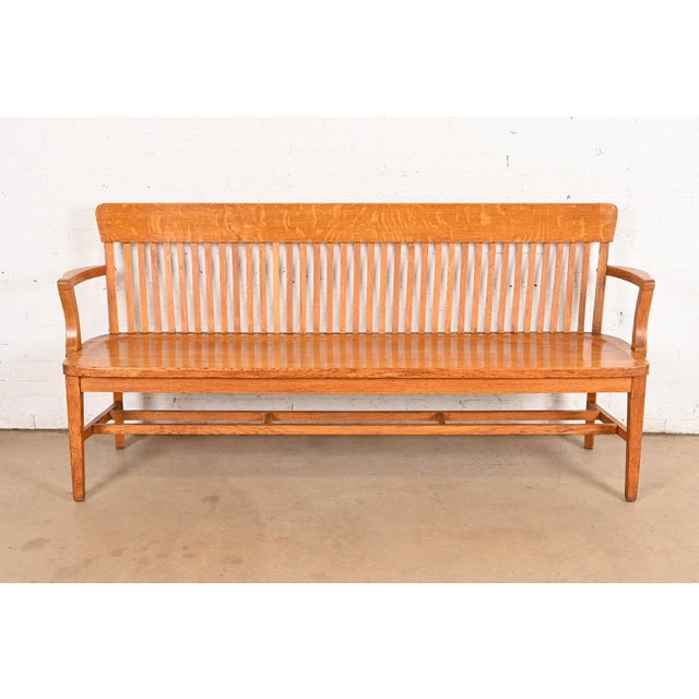 An exceptional antique Arts & Crafts solid oak spindle back banker or lawyer bench USA, Early 20th Century Measures:...