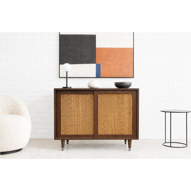 Mid Century Modern Cabinet featuring distinctive caned front doors that add texture and character. Its compact size makes...