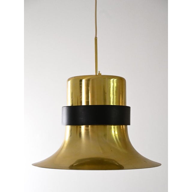 Golden metal pendant lamp with black band detail, dating back to the 1960s. The elegant and particular design, combined...