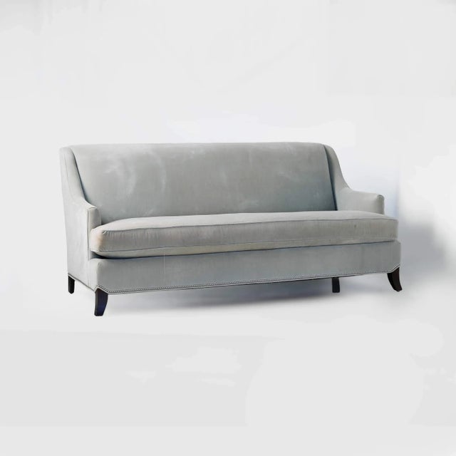 Vintage slope arm sofa in light gray velvet by Kravet Embellished with chrome tack detail along the base. Areas of...