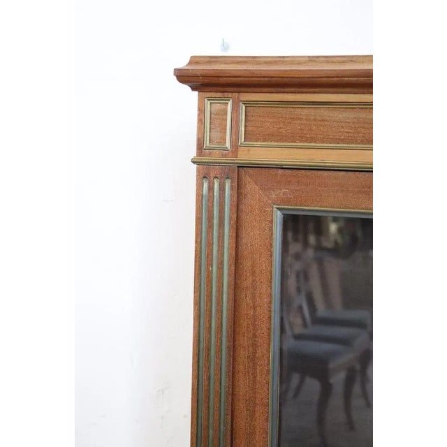 Elegant Louis XVI style vitrine characterized by finely mahogany wood. Enriched with precious frames in golden...