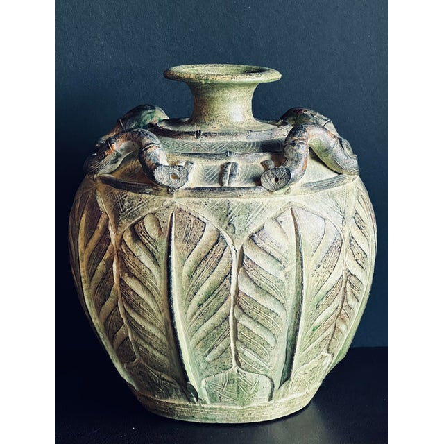 Vintage Pier 1 green vase featuring a weathered, matte green glaze, tropical leaf relief, faux rattan handles, and a...