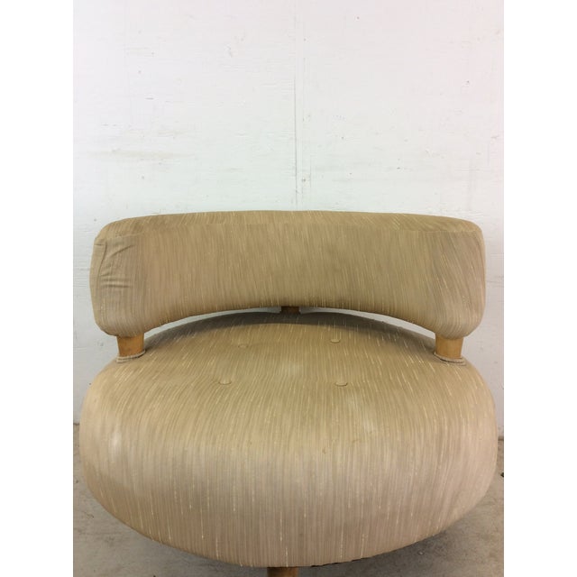 This mid century modern accent chair features vintage upholstery, unique barrel back circular design, and tapered legs.