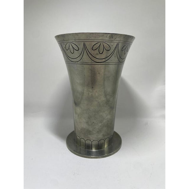A striking Art Deco pewter vase crafted by renowned Swedish silversmiths CG Hallberg in the 1930s. The vase features an...