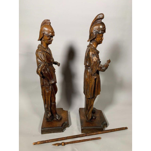 Pair of carved wooden statues, French school, 17th century. Depicts Roman soldiers piercing Christ's side with a lance....
