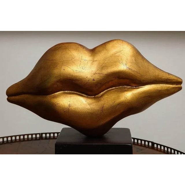 The Wooden Sculpture of the “Golden Lips” with bronze bread by Peruvian Artist Nana de La Fuente is Bold and Beautiful....